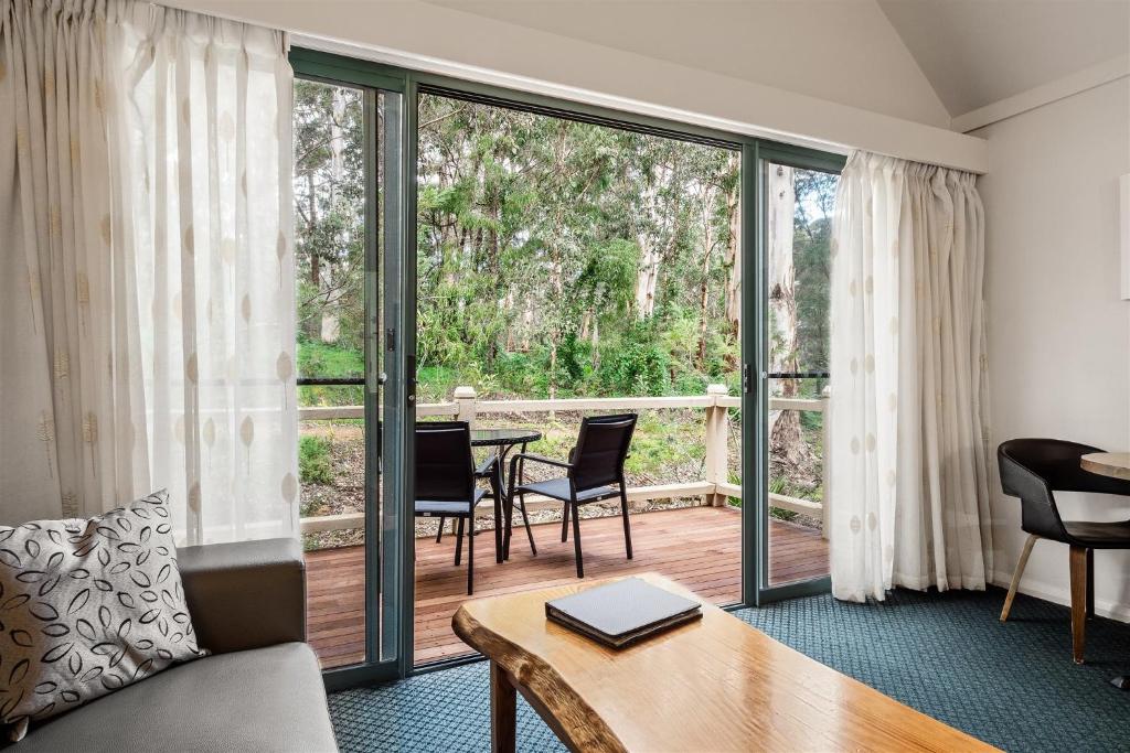 a living room with a couch and a table with chairs at Heritage Trail Lodge in Margaret River Town