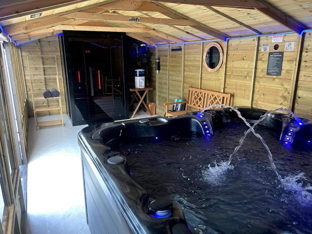 a jacuzzi tub in a house with water at Cardiff - Sleep 7- Hot tub, Sauna in Cardiff