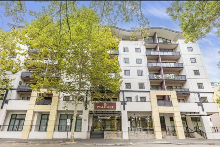 a large white building with a tree in front of it at City CBD Retreat in Perth