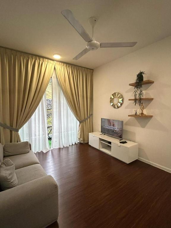 Una sala de estar con un sofá y un televisor de pantalla plana. en Ella Residence Homestay, en Brinchang