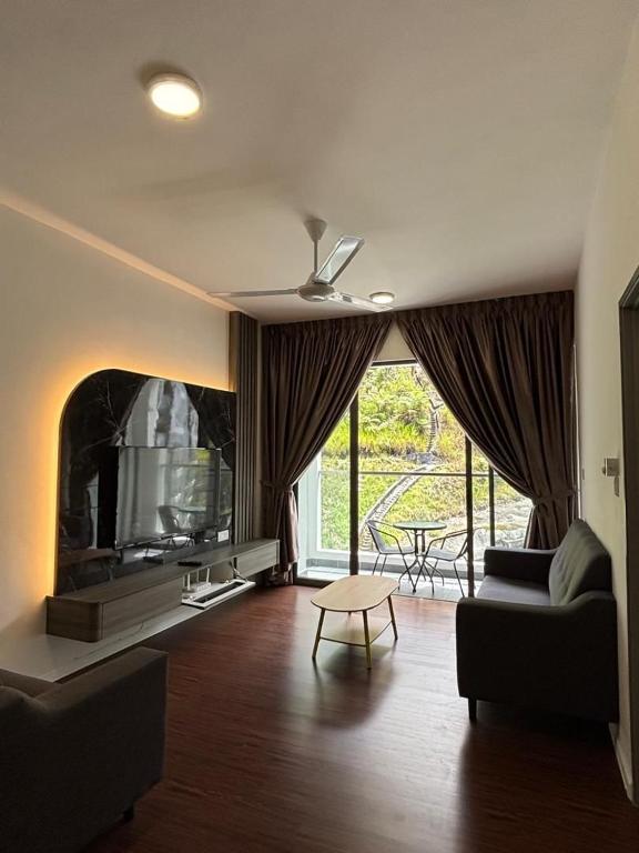 Una sala de estar con un sofá y un televisor. en Ella Residence Homestay 2, en Brinchang
