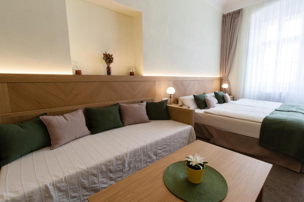 a hotel room with two beds and a couch at Karlova 25 Apartments in Prague