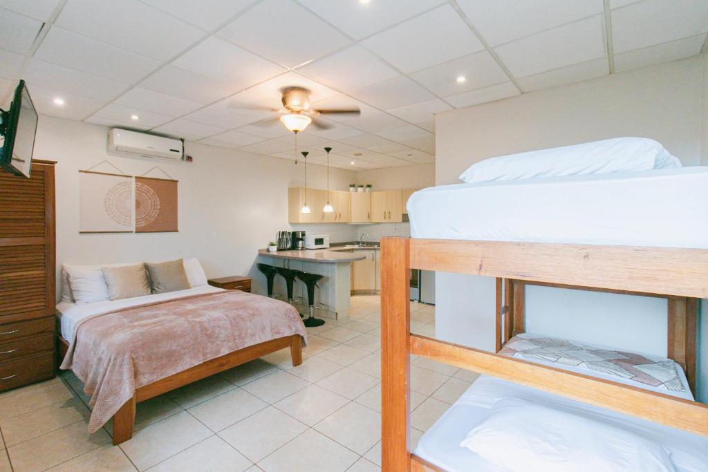 a bedroom with two bunk beds and a kitchen at Bocas Condos - Studio for 4 in Bocas del Toro