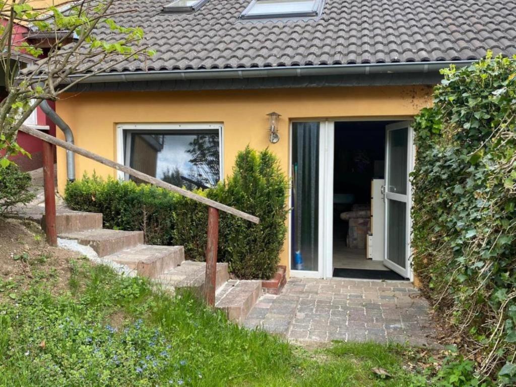 a house with stairs leading to the front door at Gemütliche Wohnung in Hellenthal in Hellenthal