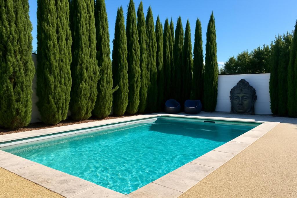 a swimming pool in front of a fence with trees at Bundalong River Retreat & Poolside Bliss in Bundalong