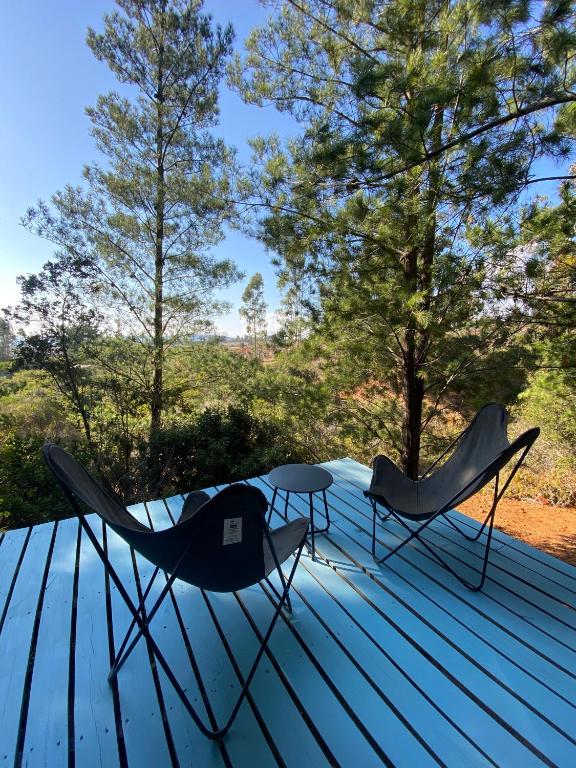 a deck with two chairs and a table on it at Tiny Houses del bosque in Pichilemu