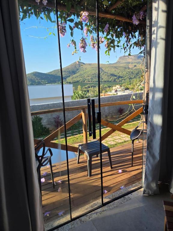 a room with a view of a deck with a bench at Chalés Vista dos Carvalhos in Capitólio