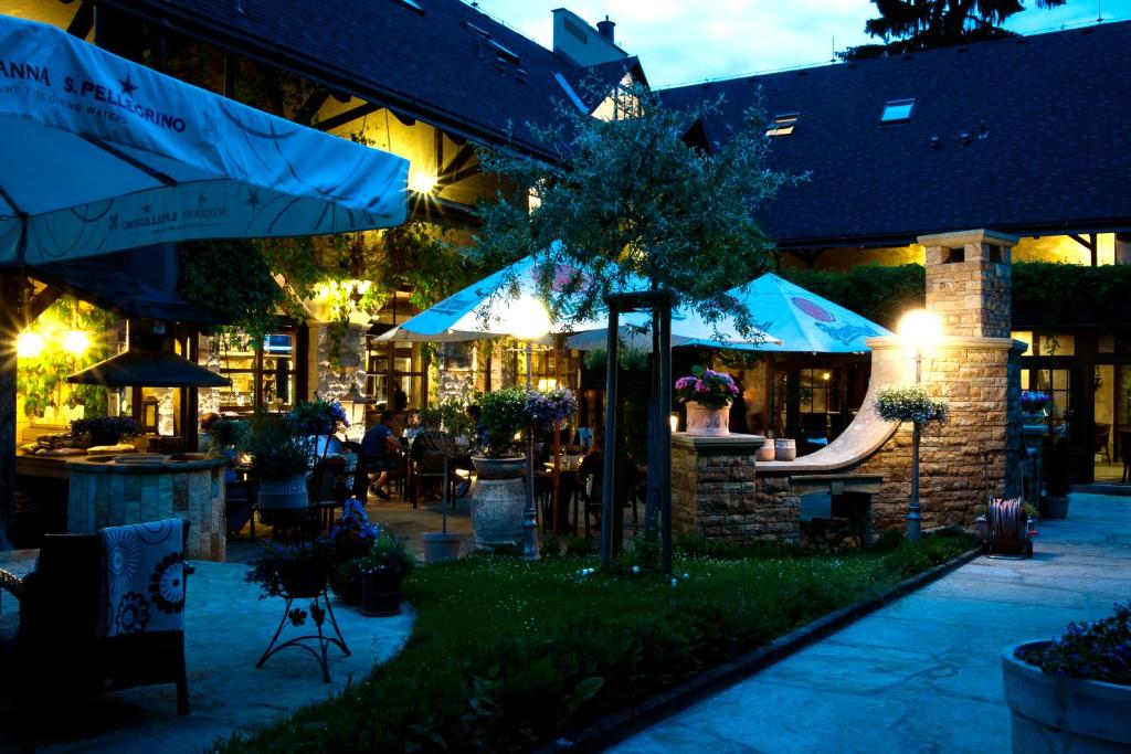 a restaurant with tables and umbrellas at night at Bonato Hotel in Náchod