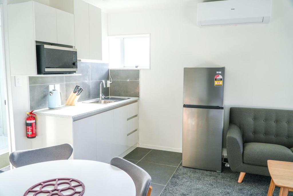 a kitchen with a stainless steel refrigerator and a table at Saints Apartment Junior Suite in Taupo