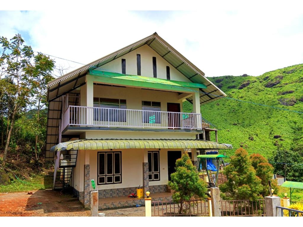 a house with a balcony on top of it at Greens Vagamon in Vagamon