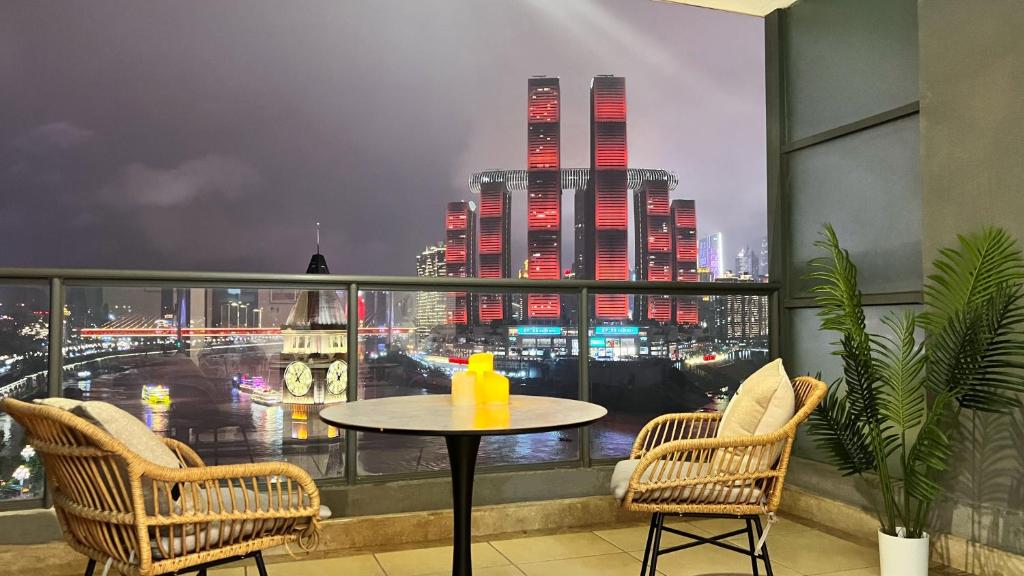 a table on a balcony with a view of a city at Chongqing Yifang B&B in Nan'an