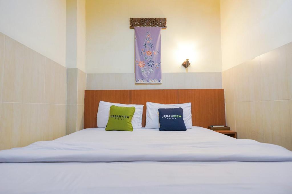 a bedroom with a white bed with two pillows at Urbanview Hotel 58 Bintaro in Pondoklang