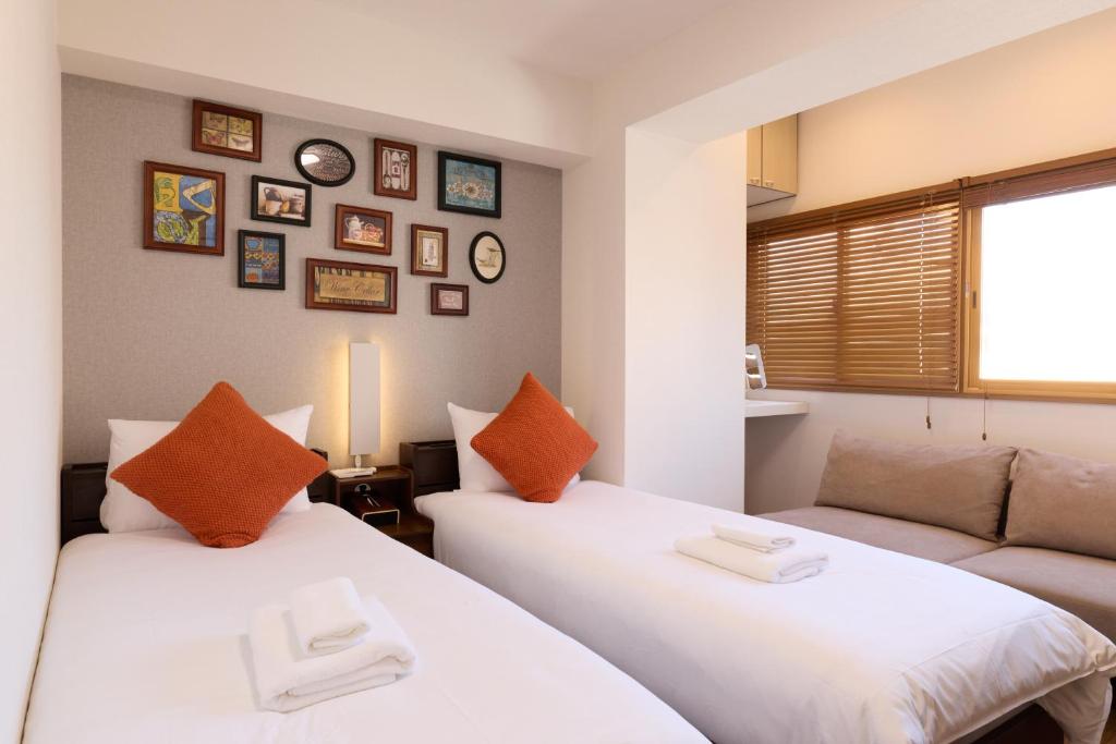 two beds in a room with a couch at Home Story in Tokyo Ueno&Uguisudani-小島ビル&東京屋語 in Tokyo