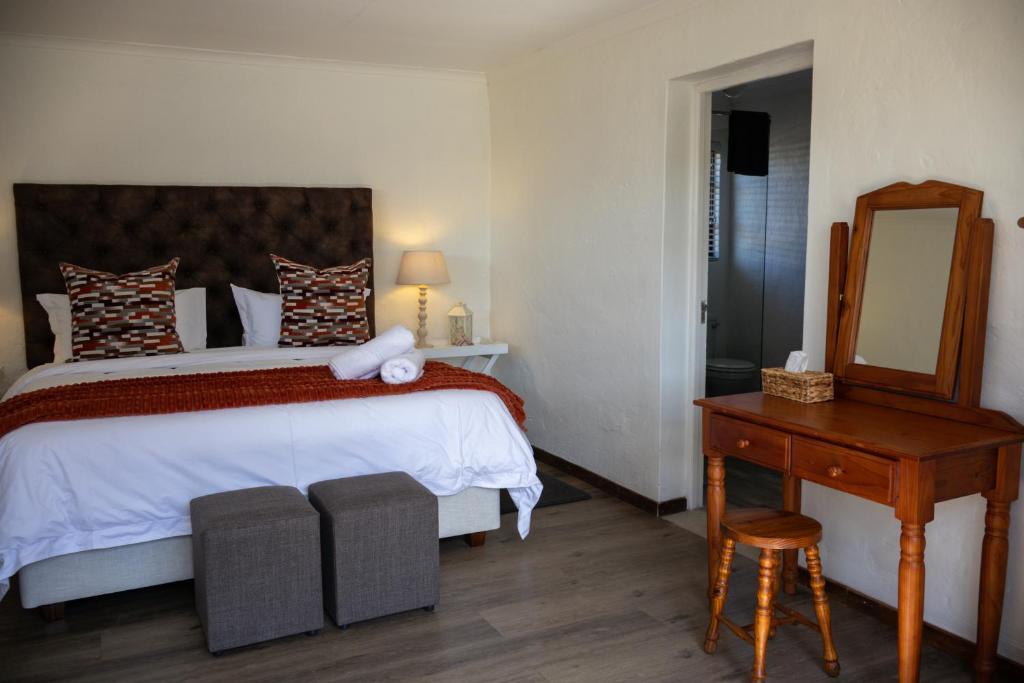ein Schlafzimmer mit einem Bett, einem Tisch und einem Spiegel in der Unterkunft Willowdale Farm Cottage 2 in Nottingham Road