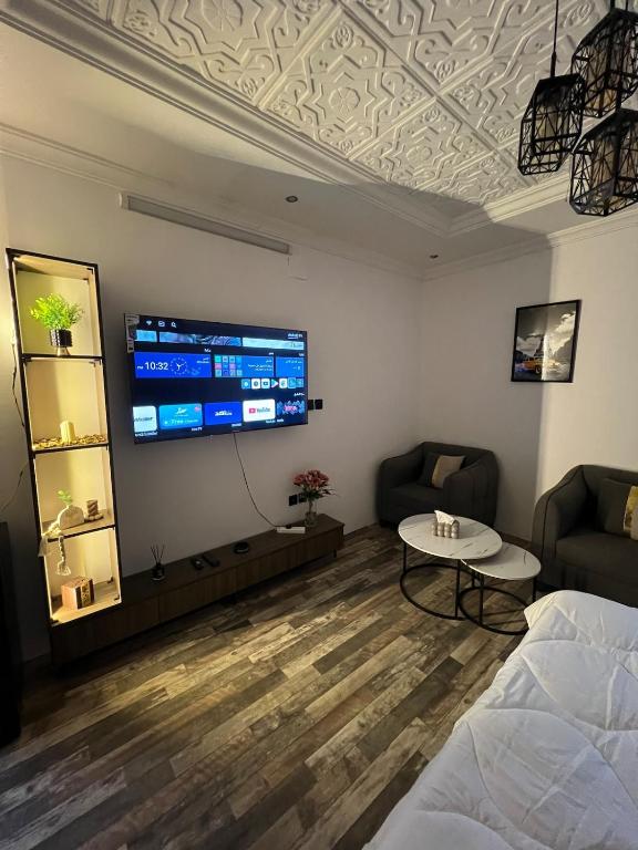 a room with a bed and a tv on a wall at Self-entry studio in Jeddah