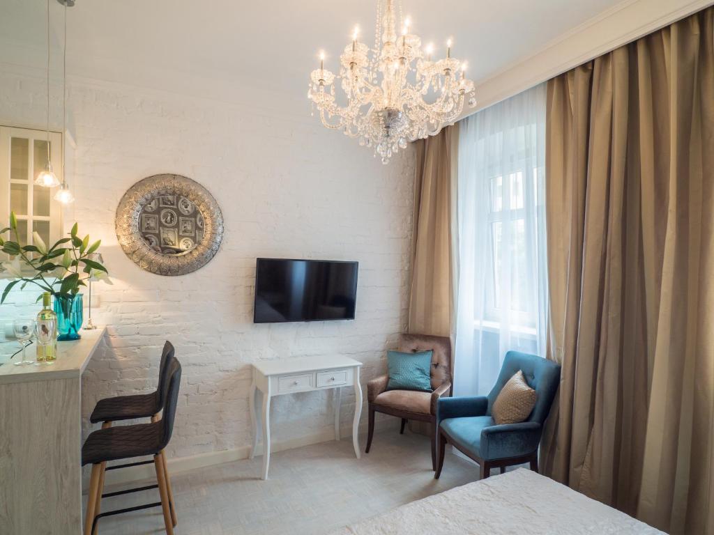 a bedroom with a chandelier and a room with a bed and chairs at Best Apartments Więzienna in Wrocław