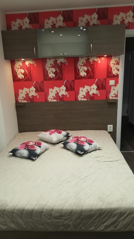 a bed with three pillows on top of it at Luxe Apartment Pana Green Residence Panagyurishte in Panagyurishte