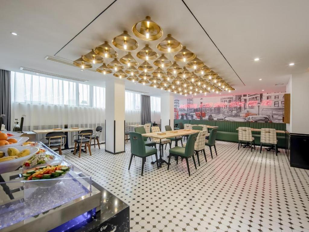 une salle à manger avec des tables et des chaises dans un restaurant dans l'établissement City Comfort Premier Hotel Qinzhou Lingshan Traditional Chinese Medicine Hospital Gymnasium, à Lingshan