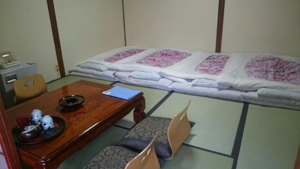Postel nebo postele na pokoji v ubytování Takigawa Ryokan