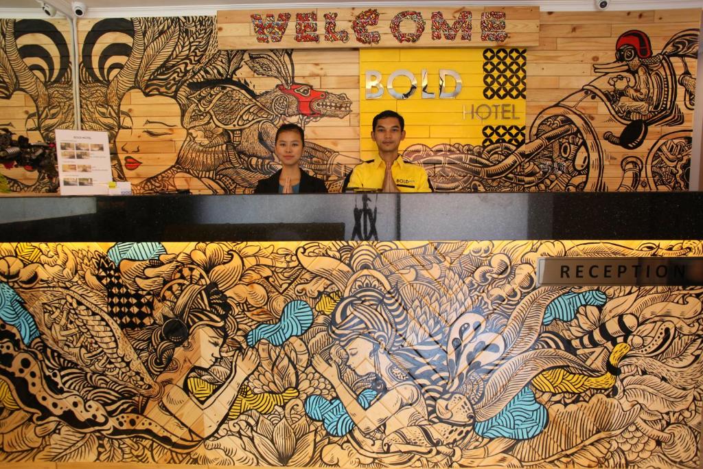 dos personas parados frente a una pared con un mural en Bold Hotel Jakarta, en Yakarta