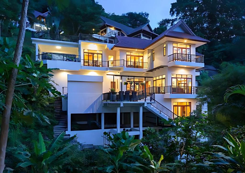 a white house with its lights on at night at Heavenly Villas in Patong Beach