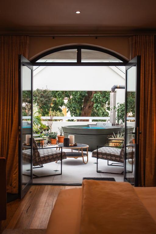 an open door to a patio with a table and chairs at Le Petit Manoir Boutique Hotel in Franschhoek