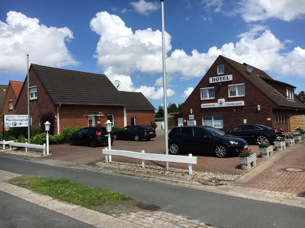 a hotel with cars parked in front of a building at Hotel Nordseegruß in Norddeich