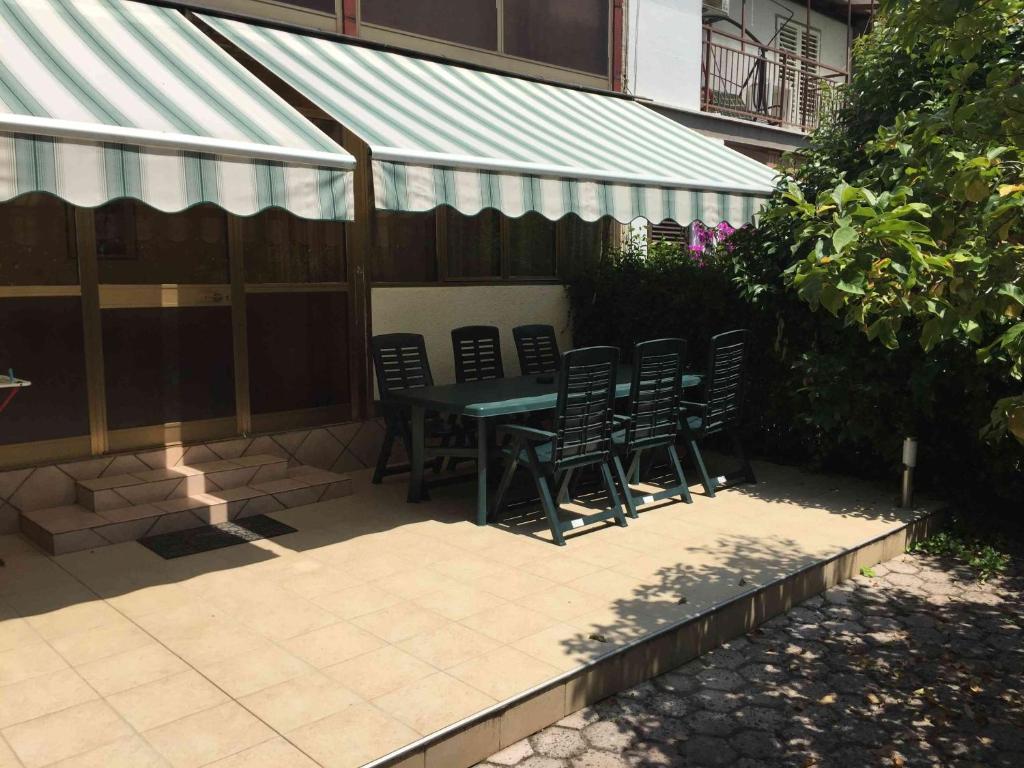 a patio with chairs and a table with awning at Apartments Oliva in Poreč