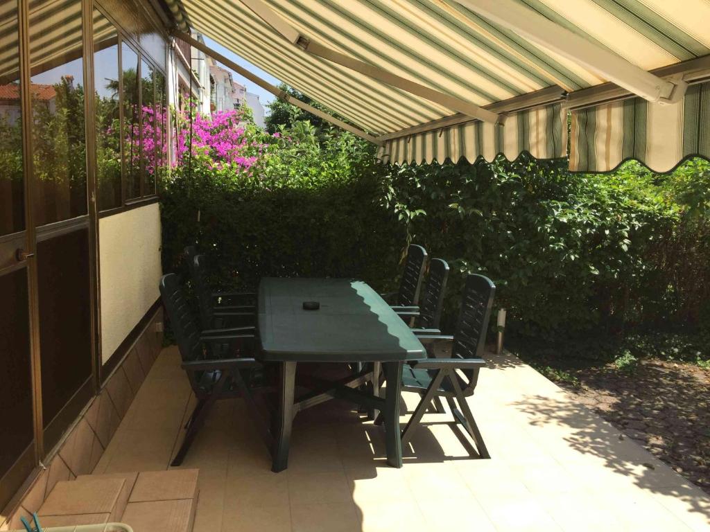 a picnic table and chairs sitting under a pergola at Apartments Oliva in Poreč