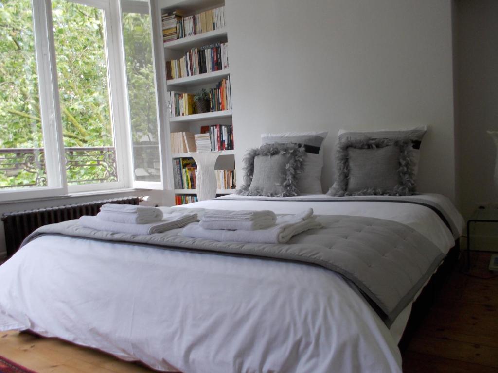- une chambre avec un grand lit blanc et 2 fenêtres dans l'établissement Au Cœur De Lille, à Lille