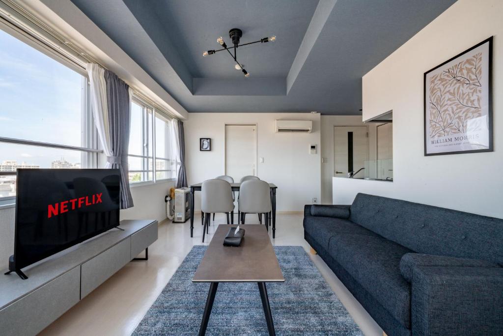a living room with a couch and a tv at Hills Garden 405 in Sapporo