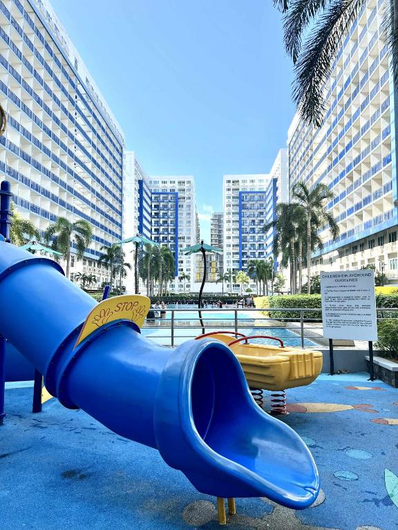 a blue slide in a playground with buildings in the background at Dvine Era Staycation in Manila