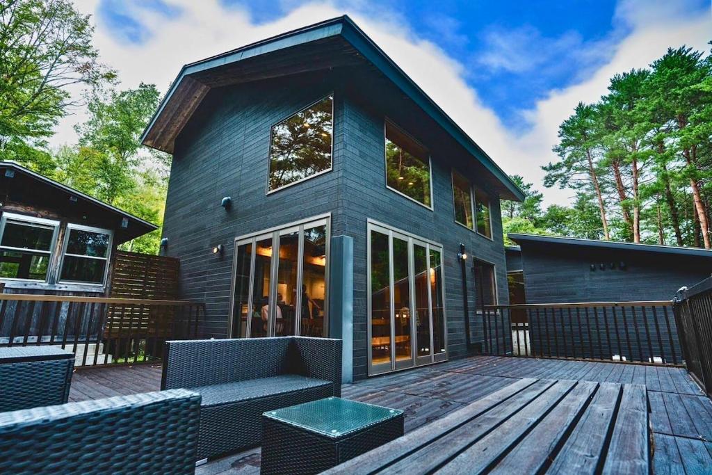 a house with a wooden deck with chairs on it at Starry sky, private sauna Achi Village Villa for 10 people Luxury in nature under the best starry sky in Japan in Achi