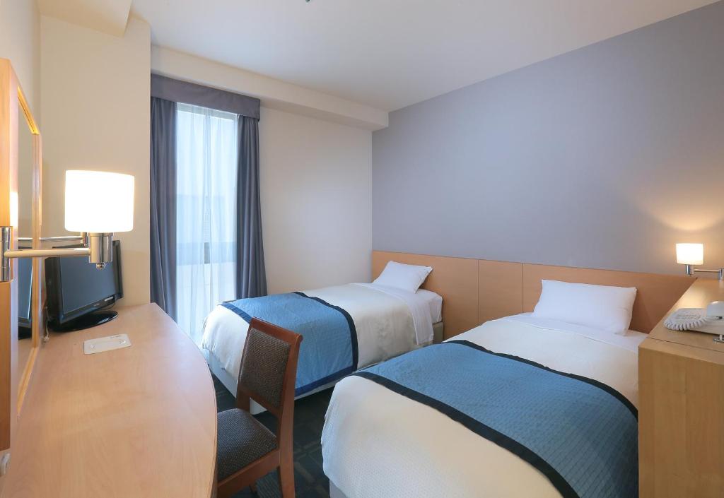 埼玉的住宿－浦和華盛頓酒店，酒店客房设有两张床和电视。