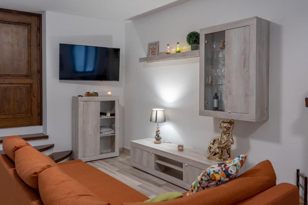 a living room with a couch and a tv at Al Laghée - New 2 Bedroom Apartment in Gravedona Center in Gravedona