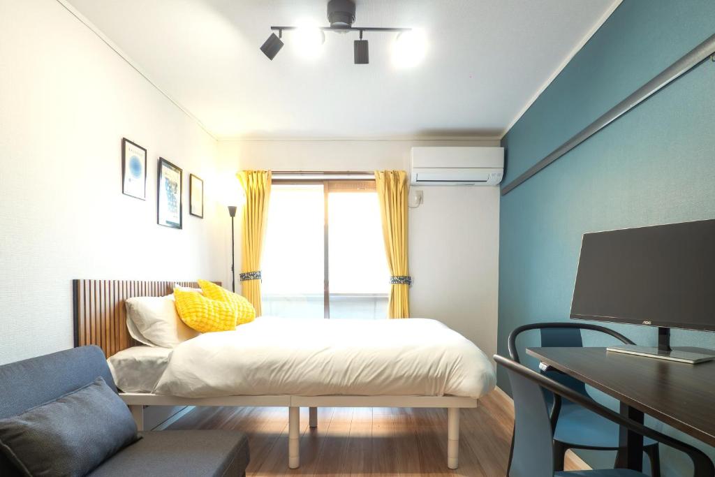 a bedroom with a bed and a desk and a tv at UPHouse 2C Gotokuji in Tokyo