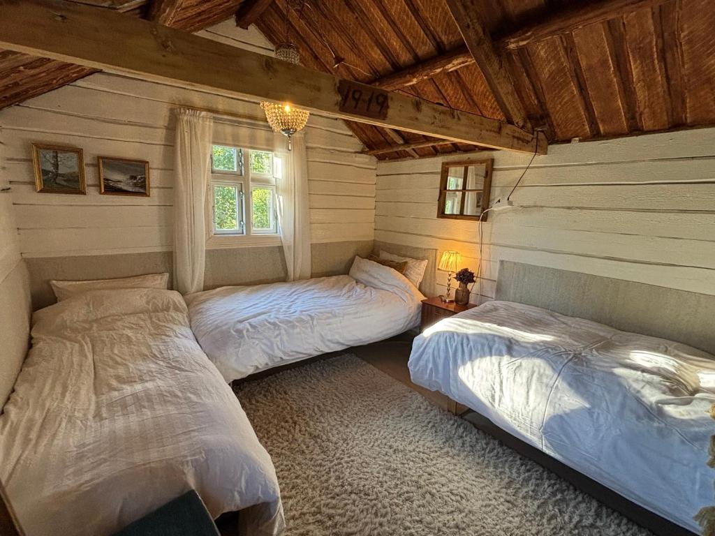 a bedroom with two beds in a room at 1850 Old Farmhouse Retreat with jacuzzi and sauna in Eidsvoll