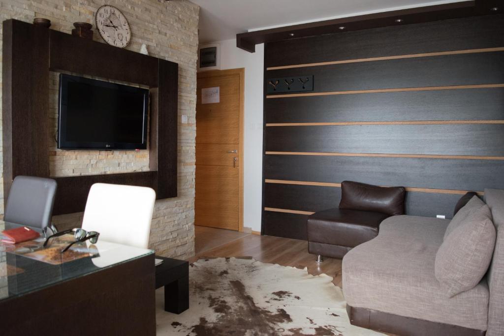 a living room with a couch and a tv at Apartment 306 in Kopaonik