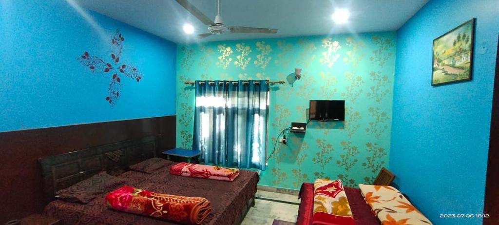 two beds in a room with blue walls at Hotel Gauri & Restaurant in Jāmb