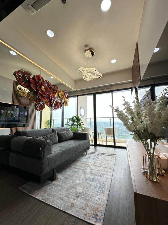 a living room with a couch and a large window at Asha suite by Patraland Amarta Apartemen in Kejayan