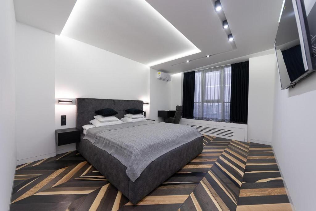 Un dormitorio con una cama y un televisor. en Victory-30 Luxe Apartment City Center, en Kiev