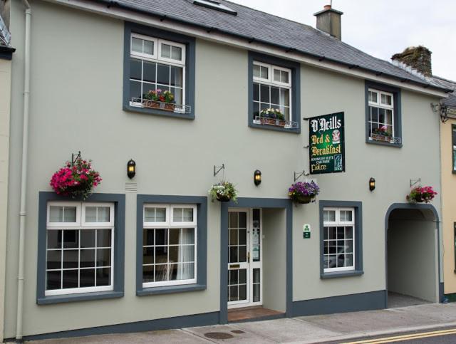 a white building with windows and a sign on it at O Neills Bed and Breakfast in Dingle
