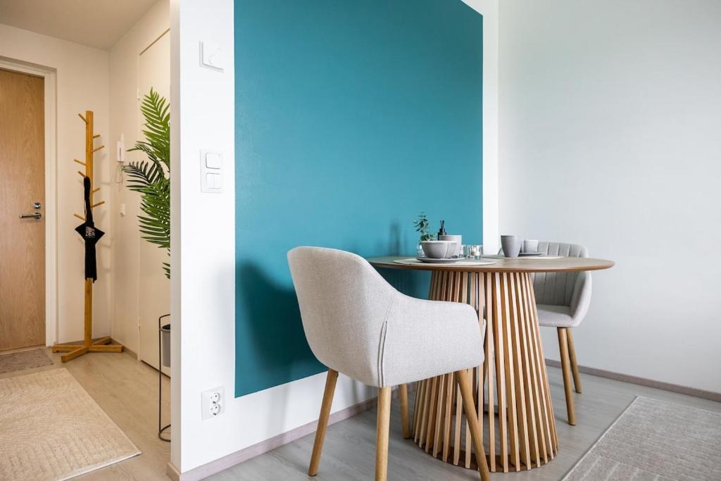 a dining room with a table and a blue wall at Lapin Kansa Suite in Rovaniemi