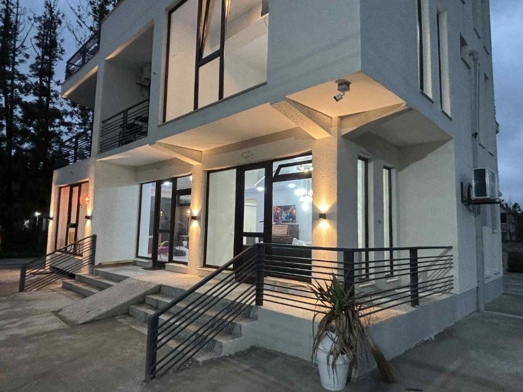 a white house with a porch and some windows at Дом Sand in Ureki