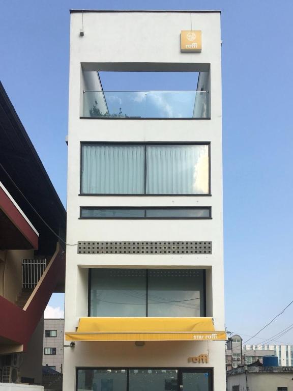 a tall white building with a large window at Gyeongju Stayrophy Eupseong Branch in Gyeongju