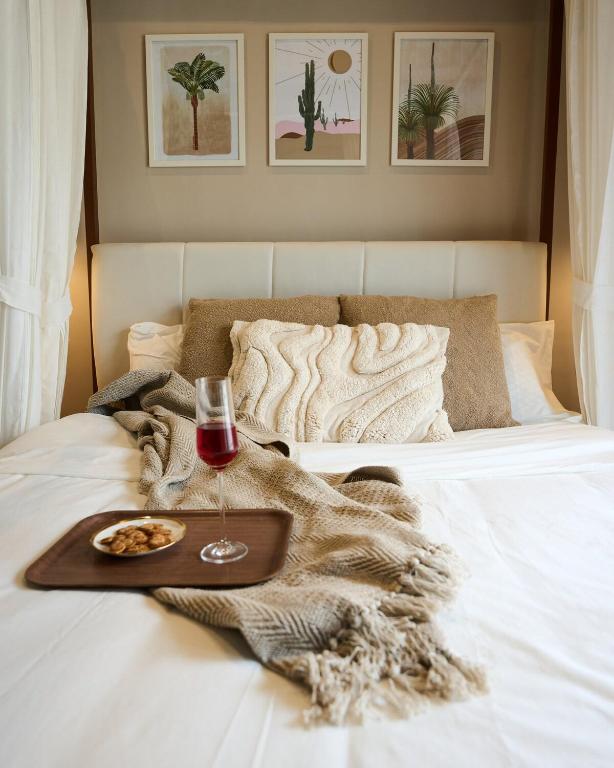 bandeja de comida y copa de vino en la cama en Miraya Villa, en Malavli