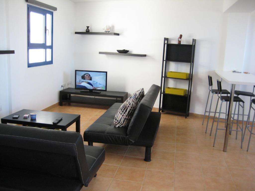 een woonkamer met een bank en een tafel bij Mirador del Roque in Orzola