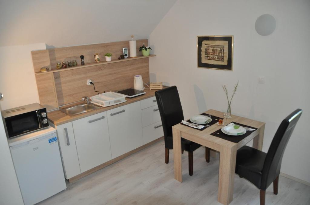 a kitchen with a table and a small table and chairs at Simpli Apartments in Ljubljana