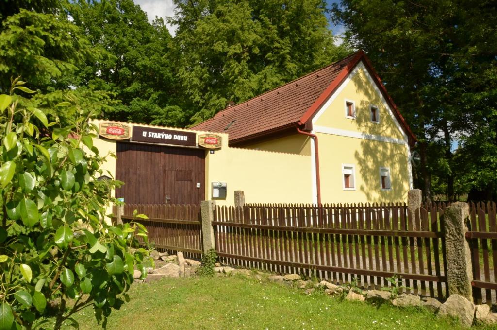a small house with a wooden fence next to it at Pension U Starýho Dubu in Jindřichŭv Hradec