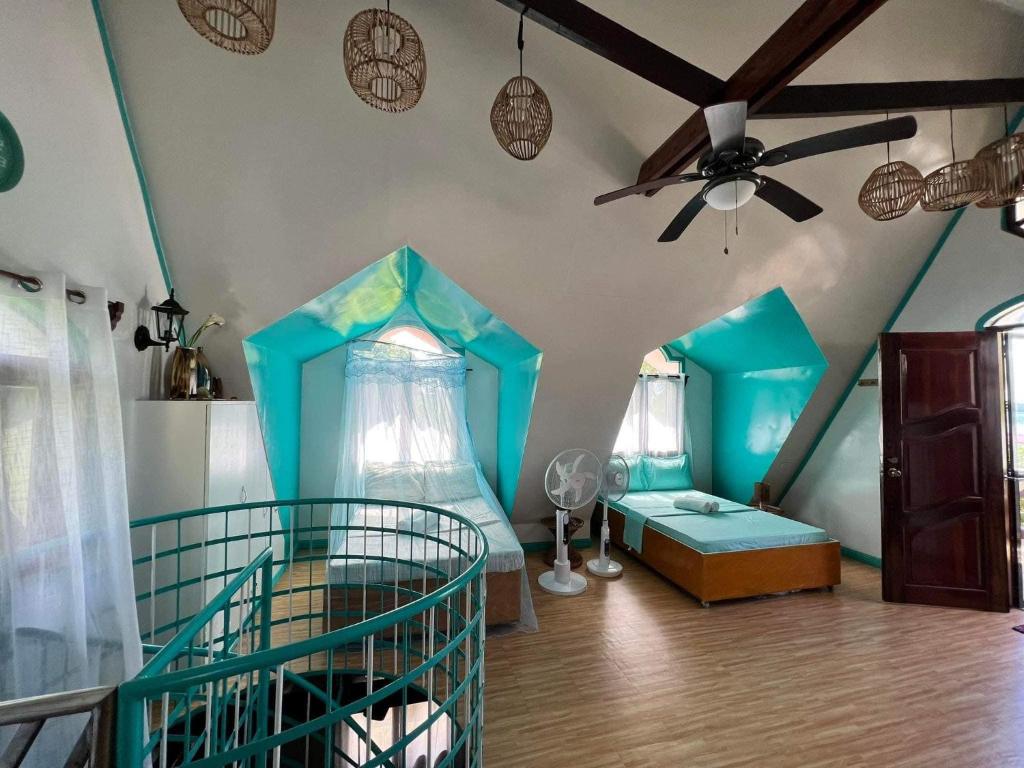 Una habitación con dos camas y un ventilador de techo. en Casa De Moore - Ocean & Garden View Siargao, en General Luna